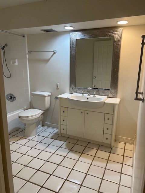 A white bathroom with a toilet, sink and mirror.